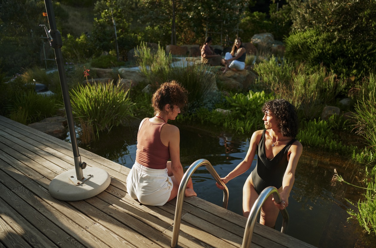 Eco-friendly pool designs featuring a natural pool with a wooden deck.
